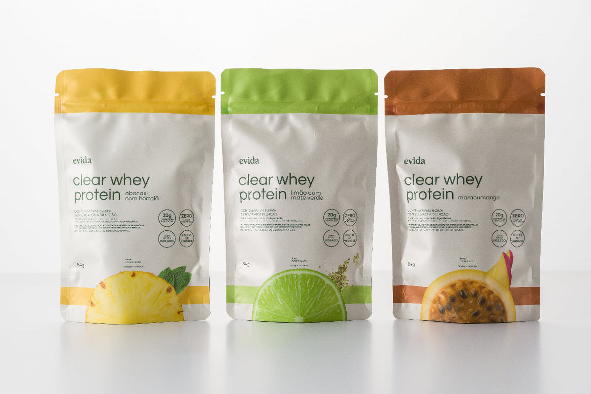 Três embalagens de clear whey protein da Evida lado a lado, nos sabores abacaxi, limão e maracujá com manga